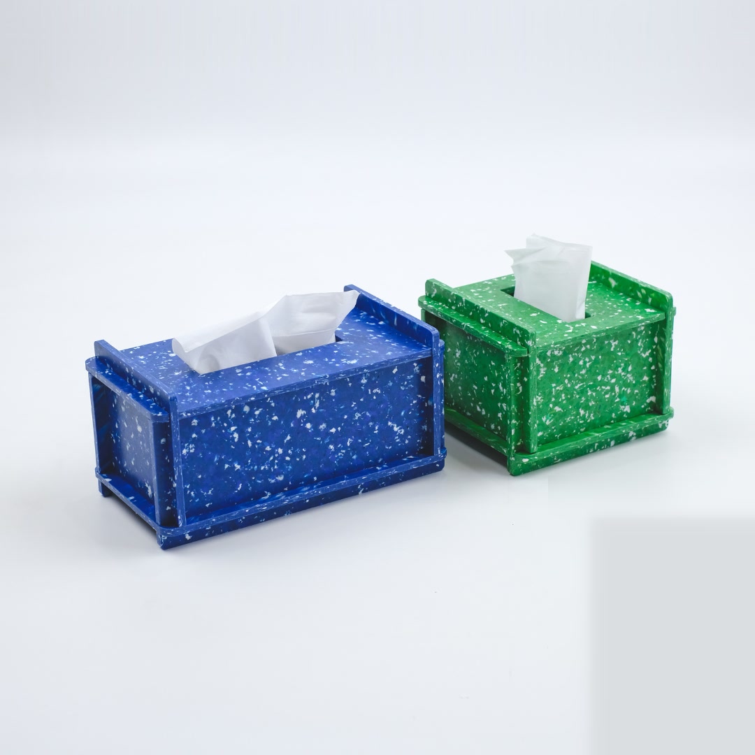 Two recycled-plastic tissue boxes, blue and green, with the terrazzo speckle